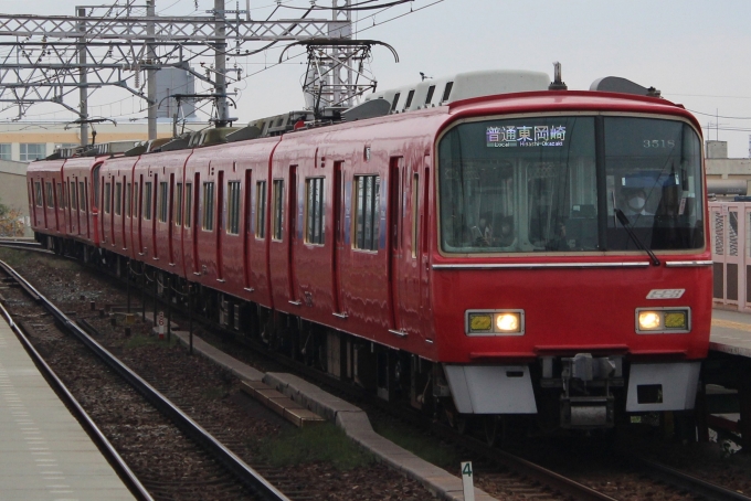 名古屋駅のビル群を背景に東枇杷島駅 付近の急カーブを曲がる名鉄2000系2006fミュースカイ中部国際空港行き。国際線も多数発着するセントレアから乗り換えなし30分で東海地方の各方面へ行ける名古屋 駅というターミナルに行けることは、セントレアからの移動を考える
