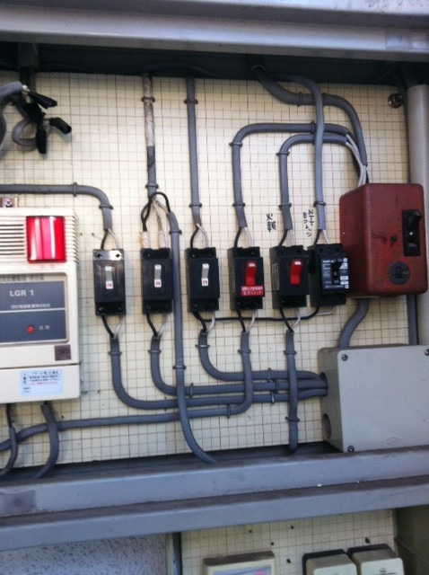 アパートの引込開閉機盤設置！今回の案件は１棟４件なのですが、４件分の家庭用と共用部分の外灯などの電気がここから供給されます。電力メーターもここに取り付けらます。設置箇所に応じて位置出し、電線管を通す穴や取付用のビス穴を削孔します。簡単に取り付けている